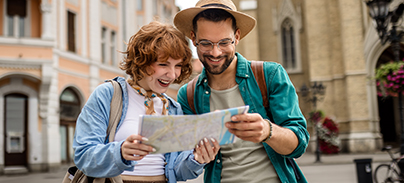 Városnéző turista pár mosolyogva nézi a térképet